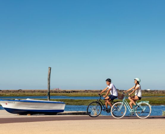 Casal anda de bicicleta perto da Ria Formosa